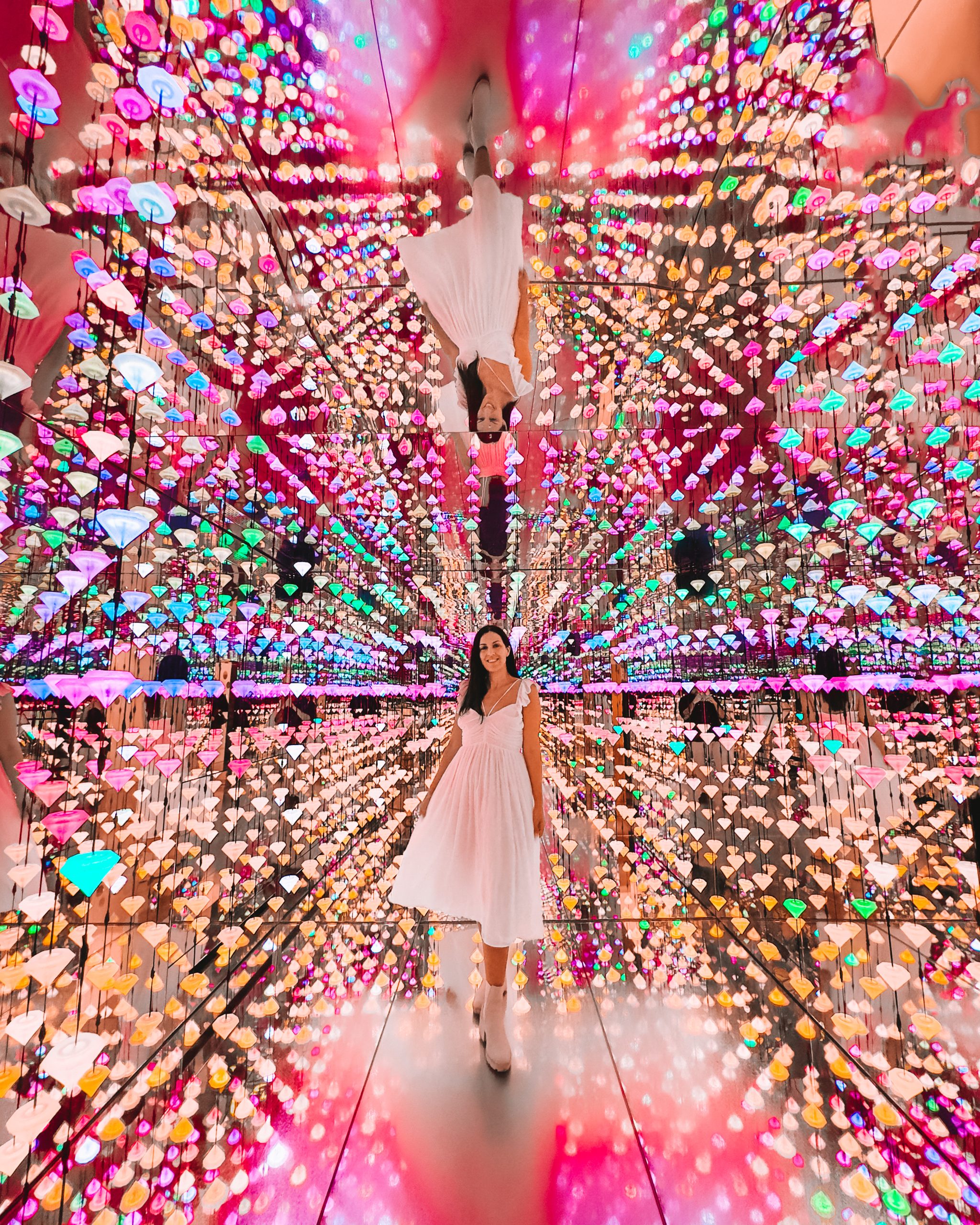 Visitor in a stunning, colorful mirrored installation at Moco Museum